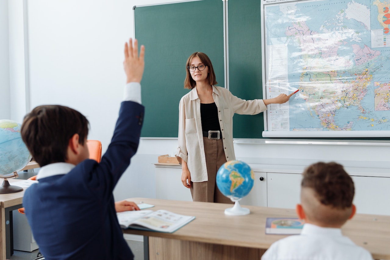 Enseignante de géorgaphie en classe devant le tableau